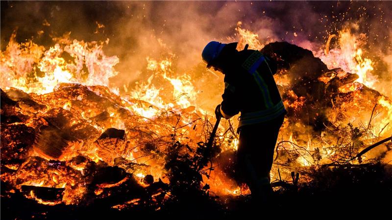 Hier schichten Feuerwehrkräfte ein traditionelles Osterfeuer im Landkreis Hildesheim auf. (Archivbild)