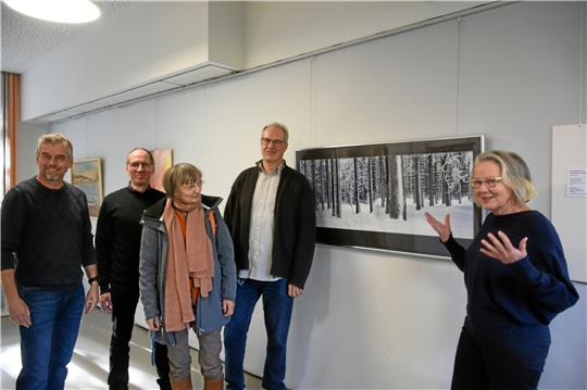 Hilda Groll erläutert ihr Fotoprojekt, aus dem die Arbeit „Damals – Winterwald im Harz“ stammt. Rede und Antwort stehen den Gästen außerdem die mit ihr Ausstellenden (v.li.) Thomas Velte, Hansjörg Hörseljau, Johanna Junk und Martin Schenk. Foto: Kempfer