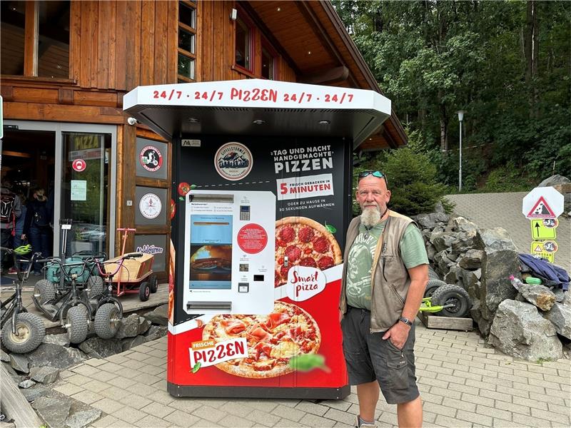 Hinrich Bothe vor seinem Pizza-Automaten, der bereits kräftig genutzt wird. Rund um die Uhr holen die Kunden (kleines Bild) die Pizzen ab, die über ein Fach herausgegeben werden. Foto: Eggers