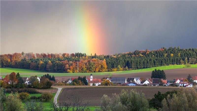 Hinter dem Dorf Dietelhofen hat sich am Morgen ein Regenbogen gebildet.