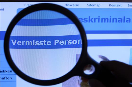 Hinter einer Lupe ist der Schriftzug "Vermisste Person" auf einem Fahndungsaufruf auf der Internetseite des Bundeskriminalamtes (BKA) zu sehen. Foto: picture alliance/dpa/dpa-Zentralbild | Jens Büttner