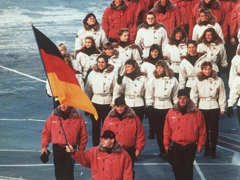 Hinter ihrem Fahnenträger zieht die deutsche Mannschaft 1992 in das Stadion von Albertville ein. Foto: Rolf Haid/dpa