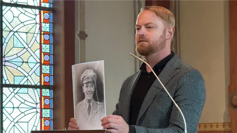 Tafel erinnert an Kriegsverbrechen in St. Andreasberg Historiker und Kirchenvorstand Frederik Kunze zeigt in seiner Ansprache ein Foto des amerikanischen Piloten und Oberleutnants John Coggeshall Saunders.