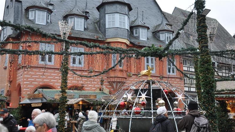 Historisches Fachwerkhaus und Menschen auf einem Weihnachtsmarkt.