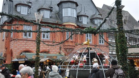 Historisches Fachwerkhaus und Menschen auf einem Weihnachtsmarkt.