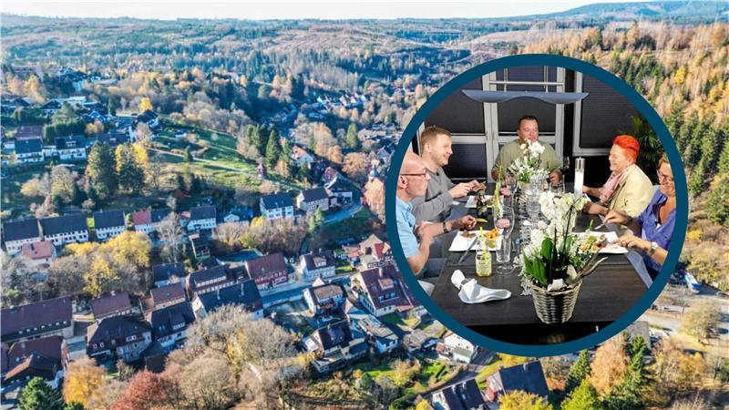Manfred, Sebastian, Gastgeber Jens, Elke und Andrea aus dem Harz sitzen an einem Tisch. Im Hintergrund ist eine Luftaufnahme des Oberharzer Ortes Altenau zu sehen.