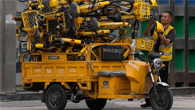 Hochstapler: Ein Arbeiter scannt Leihfahrräder auf seinem Transport-Dreirad in Peking.