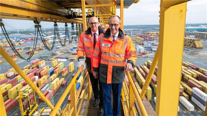 Bilder des Tages Hoffentlich schwindelfrei: Bundeskanzler Friedrich Merz und Bremens Bürgermeister Andreas Bovenschulte (SPD) stehen auf einer Containerbrücke im Überseehafen in Bremerhaven.
