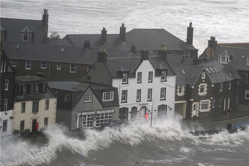 Drei Tote bei schweren Unwettern in Großbritannien Hohe Wellen brechen an einer Kaimauer an der schottischen Nordseeküste.