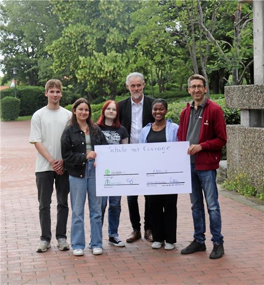 Holger Pape (erster von rechts) von den Goslarschen Höfen nimmt den Spenden-Check der Organisationsgruppe in Empfang. Die 1900 Euro stammen aus einem Spendenlauf, der genauso zum Projekttag dazugehörte, wie die Vorträge von Dilara Yasaroglu (rundes Bild unten links), Filip Sandte (rundes Bild unten rechts) und Johannes Marks. Foto: Böhnisch