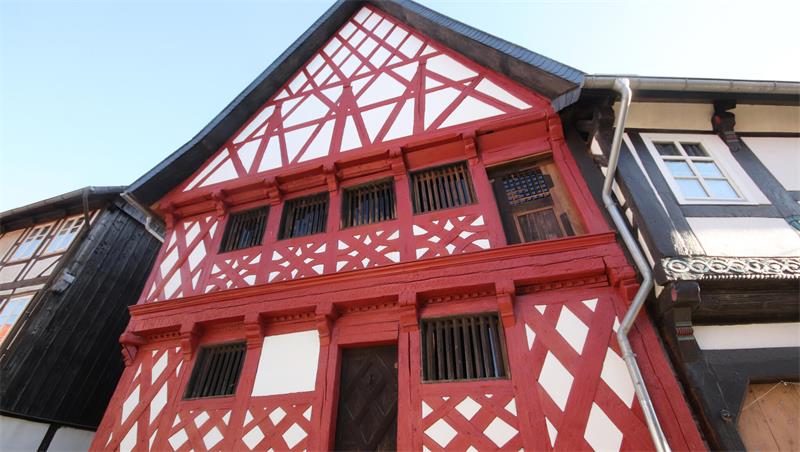 Saniertes historisches Fachwerkhaus mit roten Balken.
