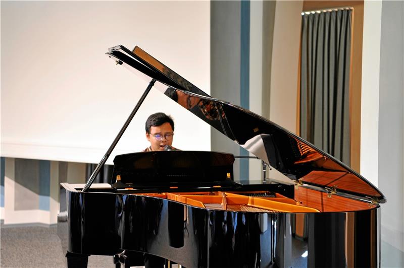 Hosea Simanjuntak begleitet die Verleihung der Urkunden am Klavier und mit Gesang.