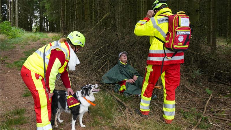 So trainieren Suchhunde im Harz für den Ernstfall Hündin Juna findet in diesem Übungs-Szenario eine verwirrte Frau im Wald. Während Halterin und Flächenhunde-Trainerin Melanie Hippauf (l.) die Spürnase belohnt, versorgt ihr Trupphelfer die Gesuchte.