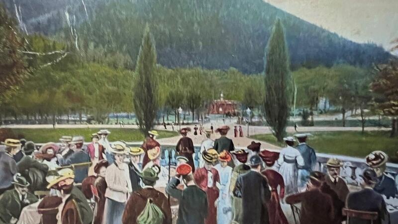 Das Bild zeigt eine Postkarte mit zahlreichen Menschen in einem Park.