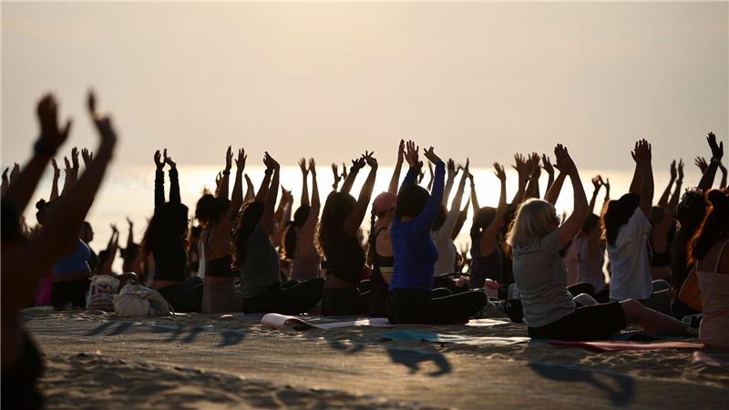 Hunderte Menschen nehmen an einer öffentlichen Yoga-Stunde am frühen Morgen am „Oak Street Beach“ am Lake Michigan teil. 