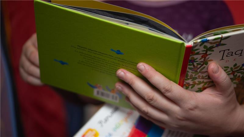 Studie: Familien bauen schnell Beziehung zu Robotern auf ILLUSTRATION. Eine Mutter liest ihrer kleinen Tochter im Kinderzimmer aus einem Buch vor.