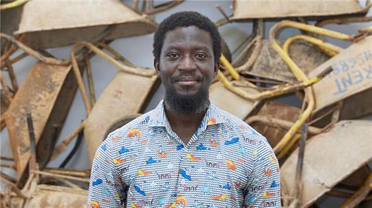 Ibrahim Mahama 2021 in Leipzig vor seiner Kunstinstallation „Vanishing Points“ mit hundert benutzten Schubkarren ghanaischer Wanderarbeiter, die dafür im Tausch neue bekamen. Foto: Punctum/Alexander Schmidt