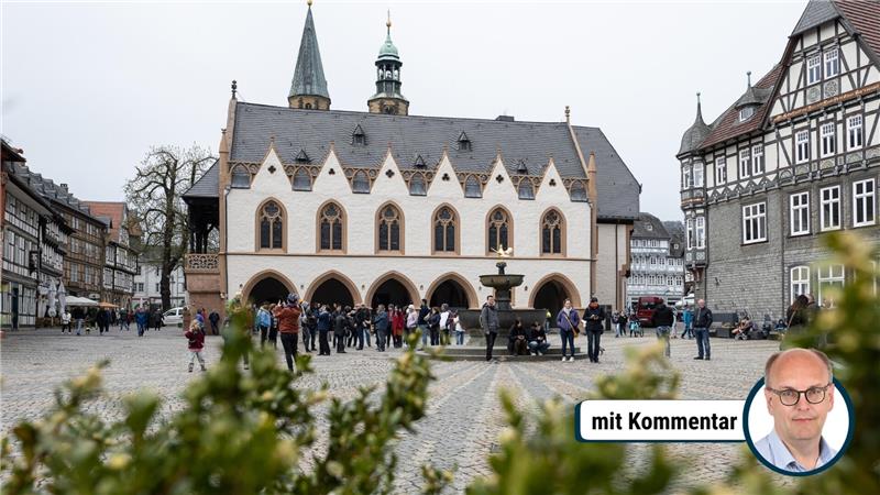 Marktplatz mit historischem Fachwerkhaus und Menschen vor einem Brunnen