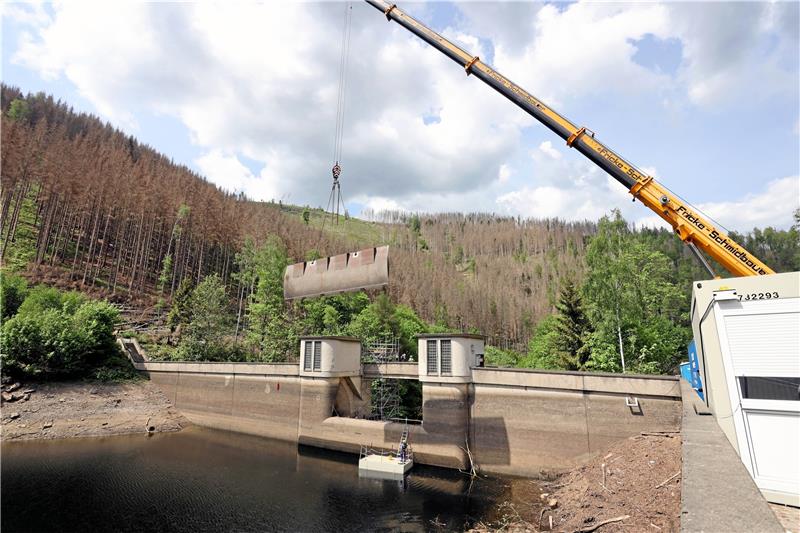 Okertalsperre bekommt eine neue Wehrklappe Im April hebt ein Kran die alte Wehrklappe aus der Staumauer. Heute soll der Nachfolger kommen. Für Antransport und Montage des rund zwölf Tonnen schweren Bauteils muss erneut die Bundesstraße gesperrt werden. Archivfoto: Neuendorf