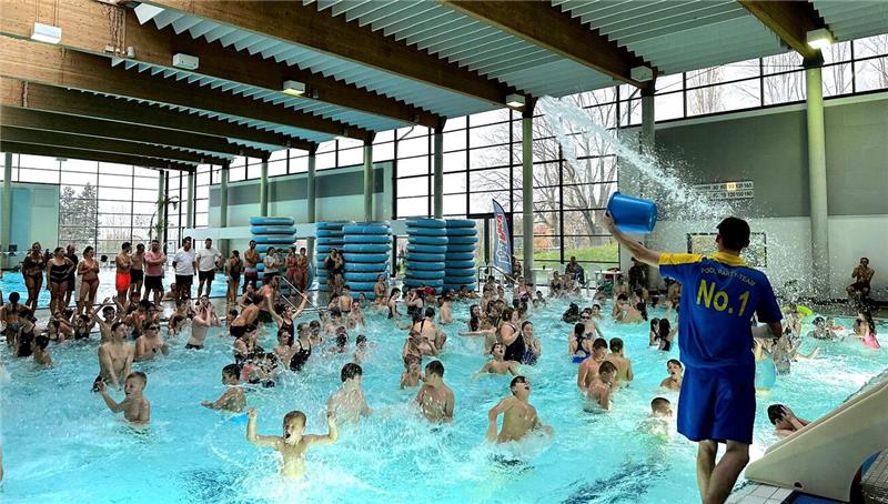 Kinder werden in einem Schwimmbecken animiert. 