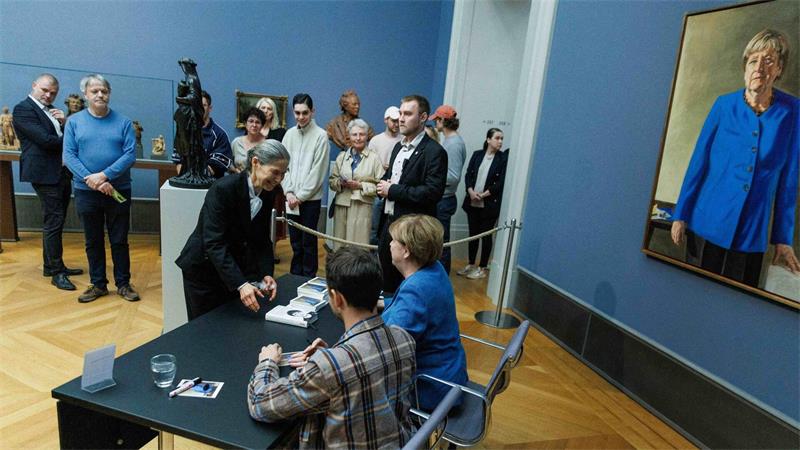 Merkel-Mania? Warum die Kanzlerin a. D. so viele Fans bewegt Im Bode-Museum signierte Merkel am Nachmittag Kunstpostkarten gemeinsam mit dem Maler ihres Porträts.