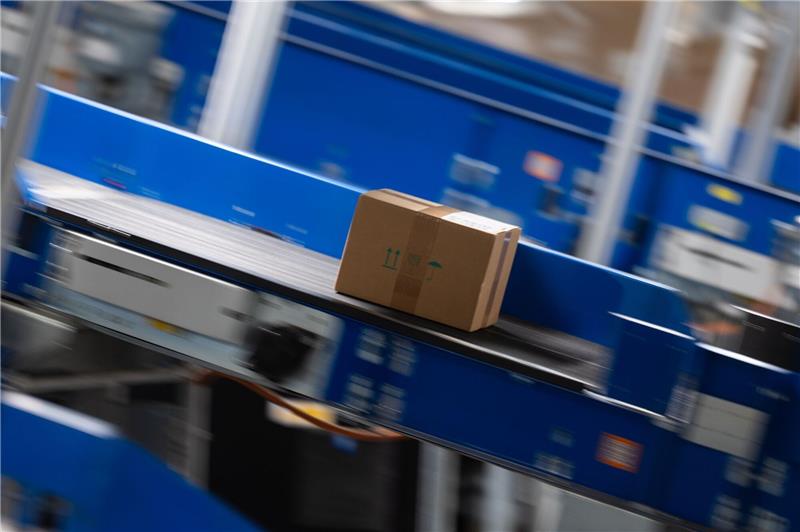 Forscher stellen Roboter für Paketzustellung vor Im DHL-Paketzentrum in Ludwigsfelde wird ein Paket über ein Laufband befördert.