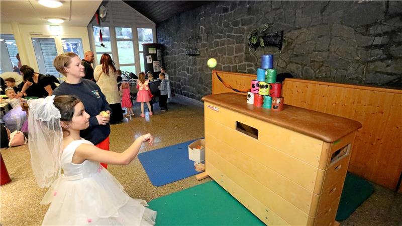 Im Foyer beweisen die Kinder ihr Geschick – unter anderem beim Dosenwerfen. Foto: Neuendorf