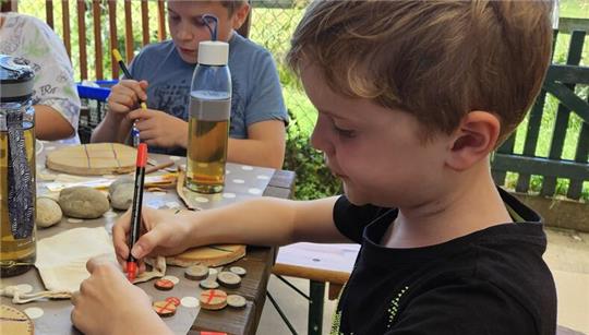 Im Garten des Jugendtreffs basteln die Ferienpasskinder ein eigenes Tic-Tac-Toe.
