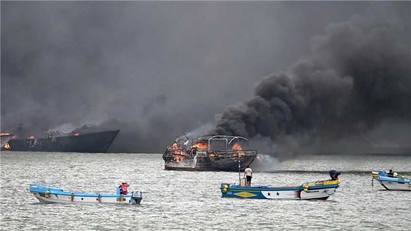 Im Hafen von Manta stehen mehrere Fischerboote in Flammen.