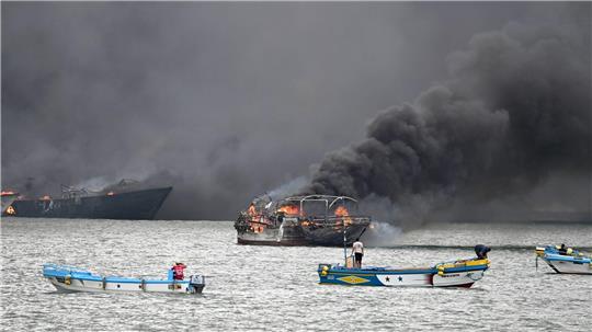 Im Hafen von Manta stehen mehrere Fischerboote in Flammen.