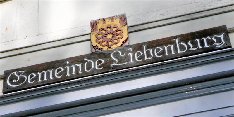 Altes Schild mit der Aufschrift "Gemeinde Liebenburg" und dem Wappen der Kommune über dem Eingang des Rathauses.