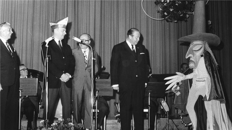 Im Juni 1971 macht die Ehrengarde der Stadt Köln Station in der Kurstadt. Begrüßt werden die Karnevalisten unter anderem vom Hexenmeister des damaligen Bündheimer Maskenspiels. 