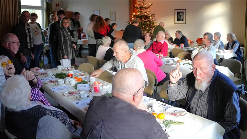 Gäste an einer Kaffeetafel im Weihnachtszimmer unterhalten sich.
