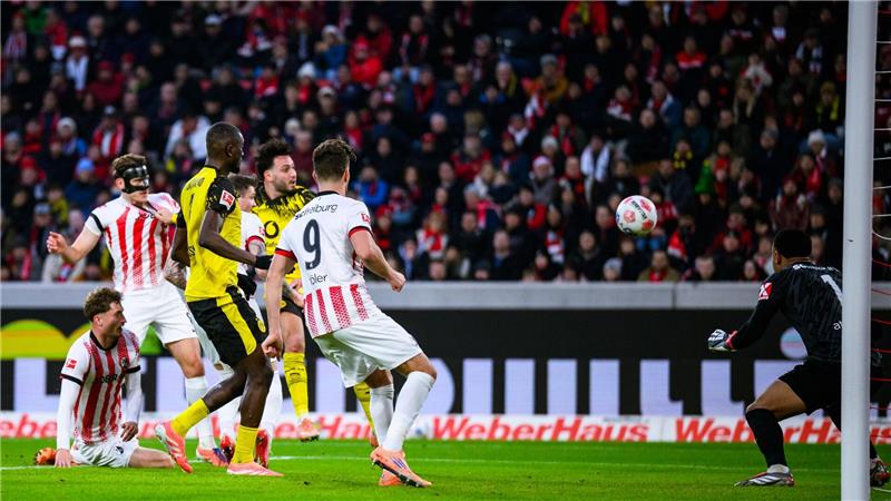 Höler-Traumtor verhindert Dortmunder Sieg in Freiburg Im Nachsetzen: Ramy Bensebaini überwindet Noah Atubolu (r.).