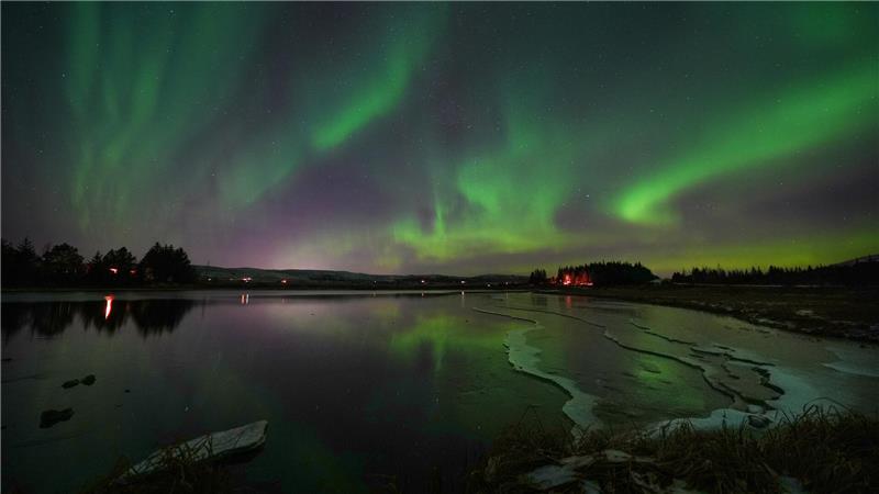 Polarlichter (Aurora borealis) spiegeln sich im Fluss Ölfusá.
