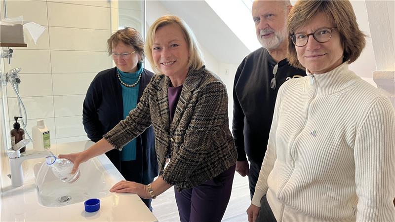 Die SPD-Bundestagsabgeordnete Dunja Kreiser nimmt eine Wasserprobe aus einem Wasserhahn.