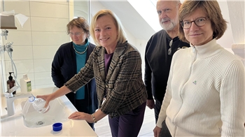 Die SPD-Bundestagsabgeordnete Dunja Kreiser nimmt eine Wasserprobe aus einem Wasserhahn.