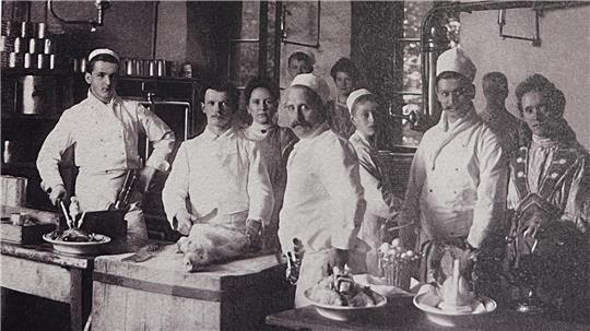 Das Bild zeigt sieben Männer und sieben Frauen in Küchen-Arbeitskleidung. Es handelt sich um Personal des einstigen Grandhotels Harzburger Hof.
