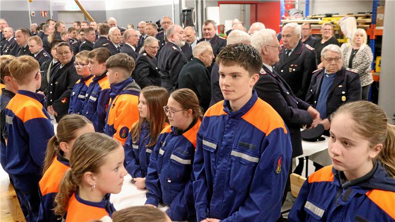 Feuerwehrleute erheben sich von ihren Plätzen.