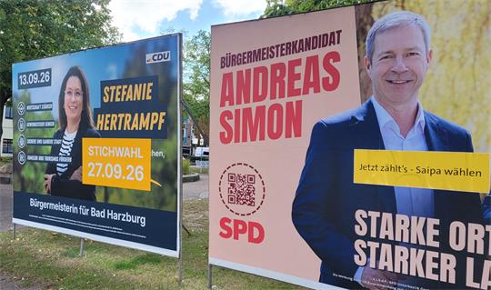 Zwei Wahlplakate, auf denen eine Frau und ein Mann abgebildet sind.