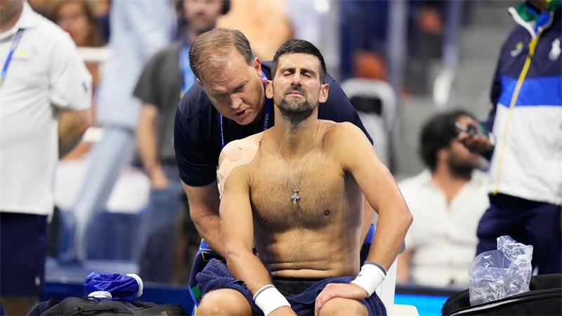 Im fünften Satz wird Novak Djokovic am Rücken behandelt.