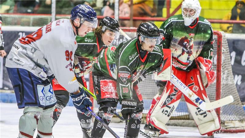 Falken holen Stürmer im Doppelpack Eishockeyspieler in grünen und weißen Trikots stehen auf dem Eis vor dem Tor, ein Torwart in grünem Trikot hält die Position im Tor