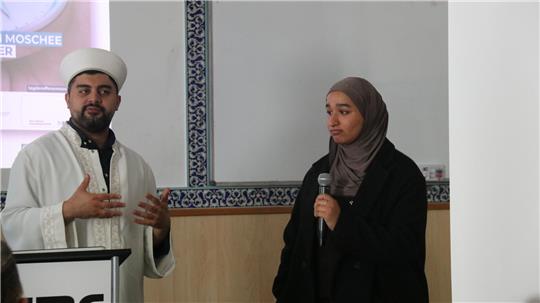 Imam Mohamed Mücahid Eker und Maryam Hammadi stellen eine Koransure vor.