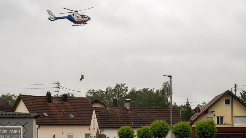 Lage zugespitzt: Menschen aus überfluteten Häusern gerettet In Babenhausen wird ein Wasserretter aus einem Polizeihubschrauber abgeseilt.