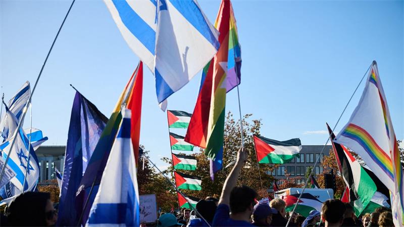 In Berlin halten Teilnehmer einer propalästinensischen Demonstration Palästinaflaggen (hinten), während die Gegendemonstration im Regierungsviertel Flaggen mit Davidsstern schwingen.