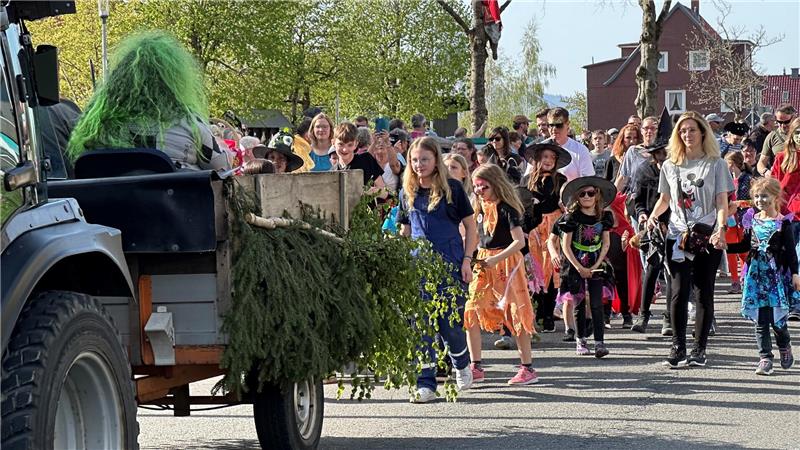 Das Foto zeigt Dutzende von Menschen, die hinter einem Traktor herlaufen.