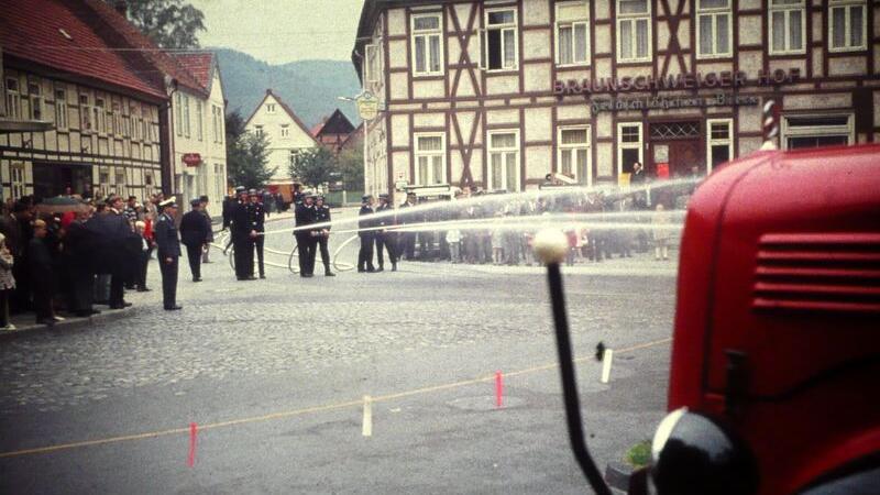 Verrücktes Festwochenende voller Traditionen und Kommers In Langelsheim wusste die Feuerwehr schon immer wie man feiert, wie dieses histoische Foto beweist. Die Kameraden demonstrieren dabei, wie man einen Brand löscht. Die interessierten Bürger schauen aufmerksam zu.