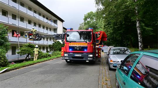 Polizeiwagen und Feuerwehrautos stehen vor dem betroffenen Wohnhaus