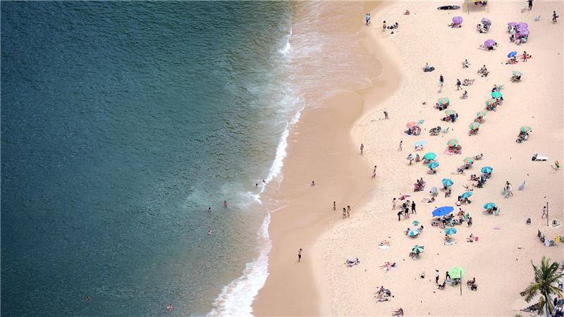 In Rio de Janeiro ist jetzt Frühling und Menschen sonnen sich am Strand.  