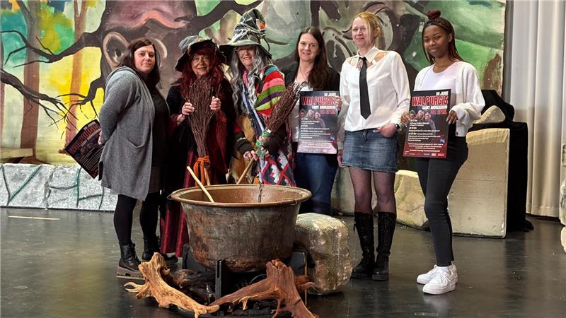 Das Foto zeigt eine Gruppe von Frauen, die vor einem Hexenkessel stehen.